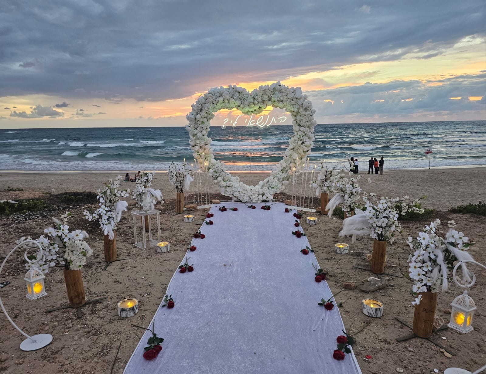 Cœur de fleurs blanches face à la mer au coucher du soleil